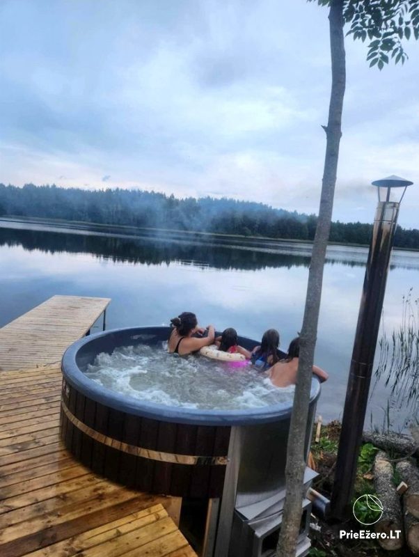 Pakirniai campsite on the shore of Lake Atvejas: paddleboards, sauna, hot tub, campers, tents.